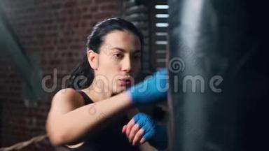 强壮的健身女士的特写镜头，在Lowmo的盒子工作室里用手套<strong>打拳</strong>击